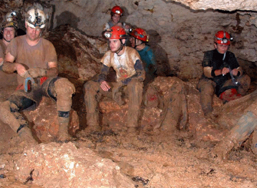 Muddy cavers dig through the mud for snack in the breakroom