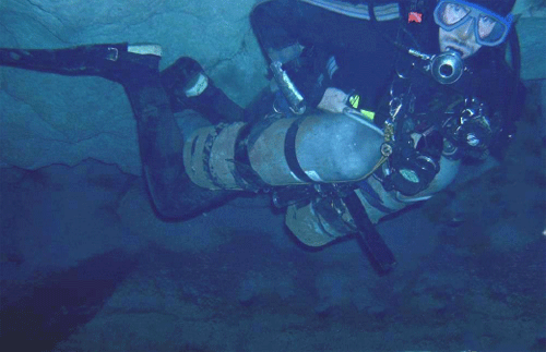 Guy Bryant in underwater passage of Climax Cave. (Note mud on tanks)