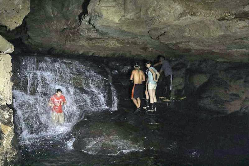 A group of people standing in a cave

Description automatically generated